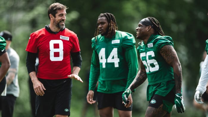 Aaron Rodgers speaks with teammates at Jets' OTAs on Monday